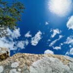Granite rock, sky with sun and overhanging tree
